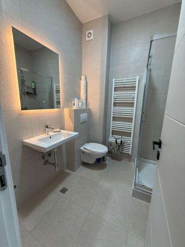 a bathroom with a sink and a toilet and a mirror at Mountain View Lux Apartment in Sarajevo