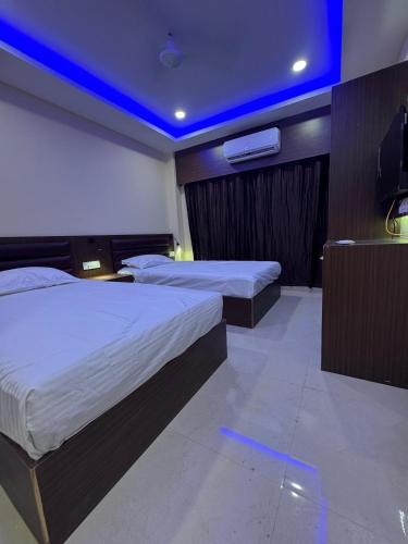 a hotel room with two beds and a blue ceiling at Hotel Dwarka Inn Pvt ltd in Janakpur
