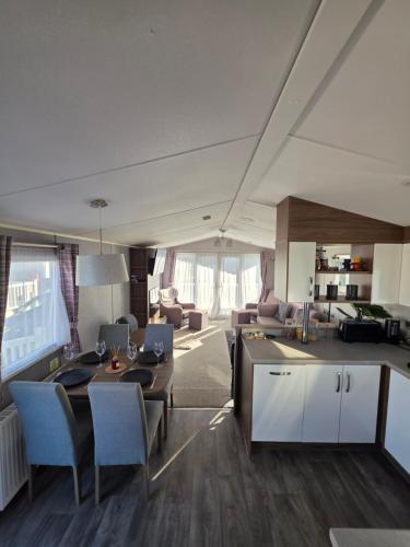a kitchen and living room with a table and chairs at H05 Par Sands in Tywardreath