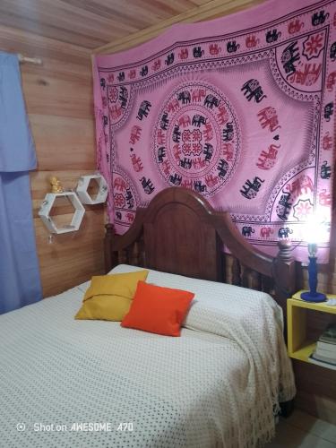 ein Schlafzimmer mit einem Bett mit einer rosa Wand in der Unterkunft La casita de Marga in Concordia