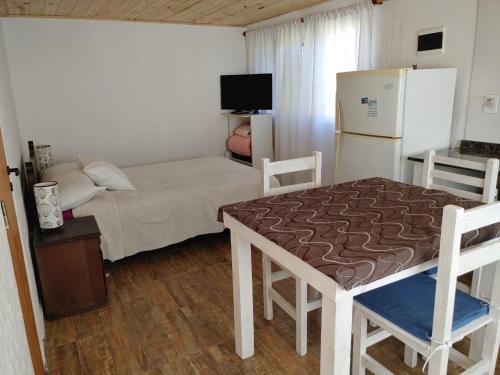 a small room with a bed and a refrigerator at Luli 1 in Villa Gesell