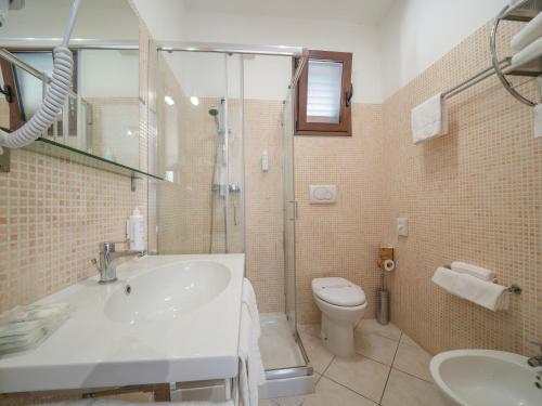 un bagno con lavandino, WC e doccia di Resort Villa Hermosa a Porto Cesareo