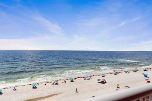 a group of people on a beach with umbrellas at 2 Bedroom Condo with Panoramic Views in Pensacola