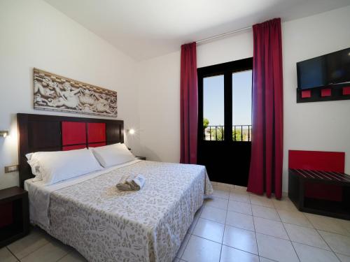 una camera da letto con un grande letto con tende rosse di Resort Villa Hermosa a Porto Cesareo