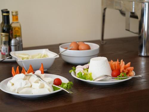 una tavola con piatti di alimenti e ciotole di ortaggi di Resort Villa Hermosa a Porto Cesareo