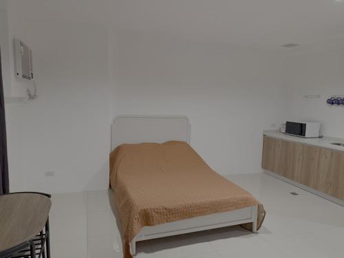 a small bed in a room with a white wall at Sitari Condo Bacolod in Bacolod