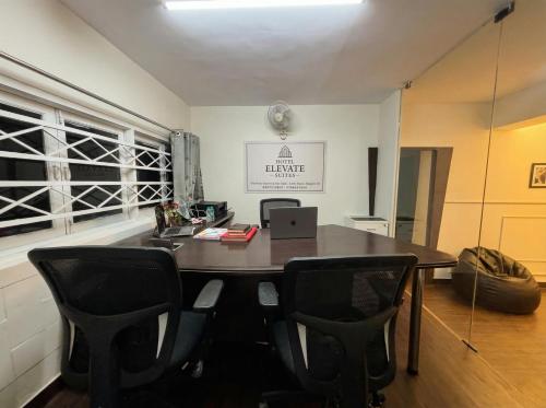 Una oficina con una mesa y sillas y una ventana. en hotel elevate suites, en Nagpur