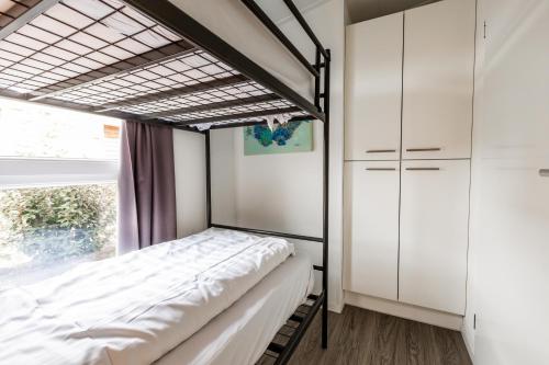 Schaelsbergerbosch Eco - Garden House Sauna copy في بيرغ إين تيربيلييت: غرفة نوم بها سرير ونافذة