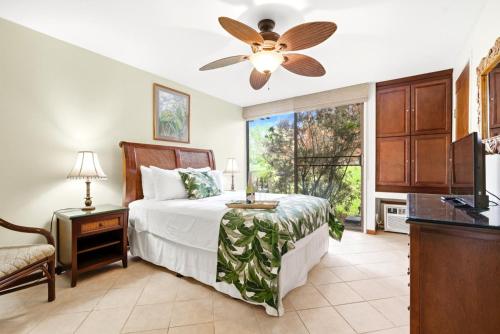 MarconiNEW Kuilima Estates West 35 FREE CAR KBM的一间卧室，里面有一张床和一个吊扇