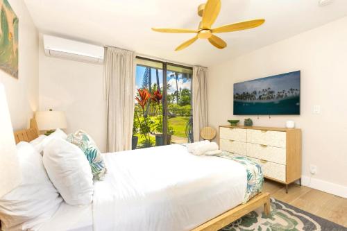 MarconiNEW Kuilima Estates West 1135 FREE CAR KBM的一间卧室，里面有一张床和一个吊扇