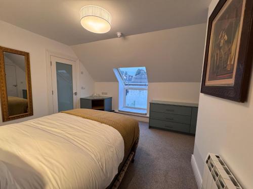 卡舍尔Cashel Regency Townhouse的一间卧室，里面有一张床和一扇大窗户。