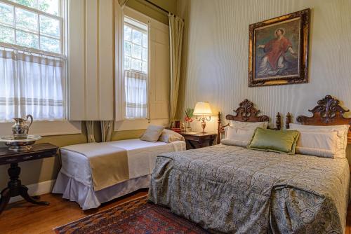 a bedroom with two beds and a painting on the wall at Fazenda São Luiz da Boa Sorte in Vassouras