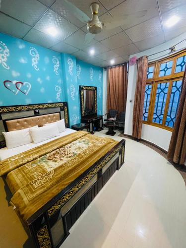 a bedroom with a large bed and blue walls at Green land hotel in Mingāora