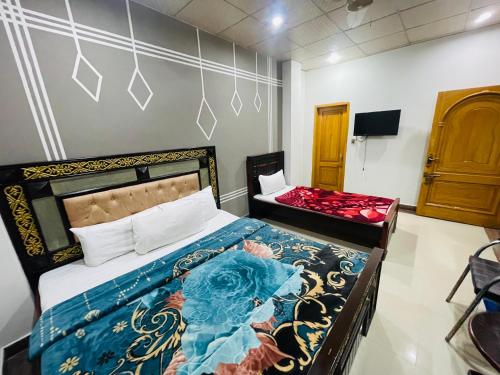 una camera da letto con un letto e una TV di Green land hotel a Mingora