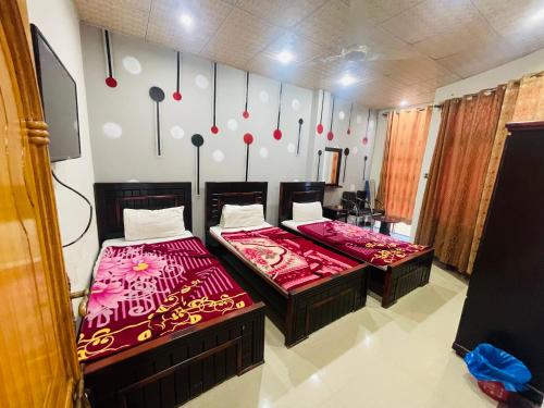 due letti uno accanto all'altro in una stanza di Green land hotel a Mingora