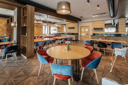 a restaurant with tables and chairs and a bar at Ведмежа гора Family Resort & Spa in Yaremche