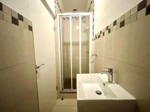 ein weißes Badezimmer mit Waschbecken und Dusche in der Unterkunft Urban L010 in Durban