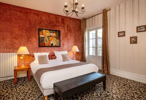 a bedroom with a bed and a red wall at Le Pavillon des Lys - Hôtel Particulier in Amboise