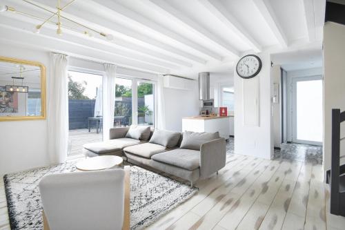 Les clos des Aviateurs في ستراسبورغ: غرفة معيشة بها أريكة وساعة على الحائط