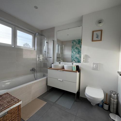 a bathroom with two sinks and a tub and a toilet at Les clos des Aviateurs in Strasbourg
