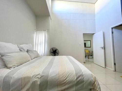 ein weißes Schlafzimmer mit einem großen Bett in einem Zimmer in der Unterkunft Urban L010 in Durban