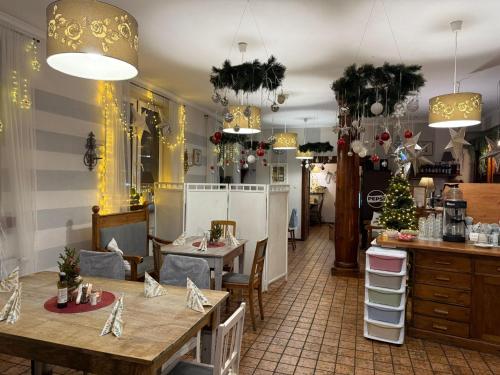 ein Restaurant mit Tischen, Stühlen und Weihnachtsdekorationen in der Unterkunft Gosciniec Pod Brzozami in Posen
