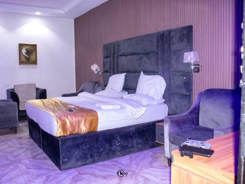 a bedroom with a large bed and a chair at Royal Dean Hotels & Suites in Mama