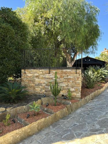 a stone retaining wall with plants in a garden at Villa Terra Alba in Le Lavandou