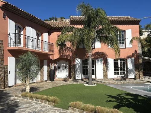 een huis met een palmboom ervoor bij Villa Terra Alba in Le Lavandou