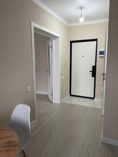 PrigorodnyyKvartira Astana的一间空房间,有白色的门和椅子