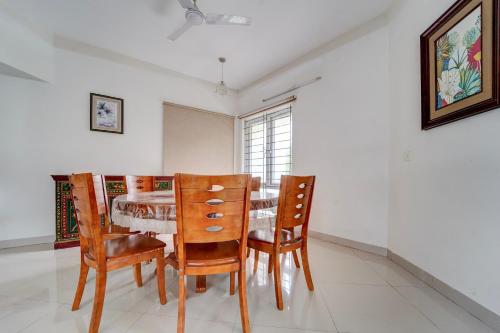 SingānallūrNirvana 4BHK by Palette | DanCenter的餐厅里有一张桌子和几把椅子