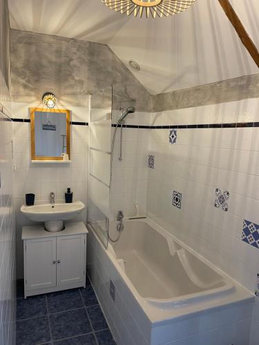 uma casa de banho com um lavatório e uma banheira e um lavatório em Le Haut Pont de la Baie em Mont-Dol