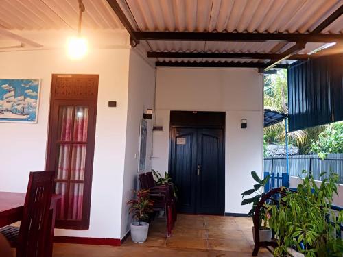 a room with a door and a table and chairs at Sunflower House Weligama in Weligama