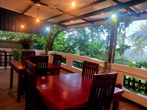 a dining room with a wooden table and chairs at Sunflower House Weligama in Weligama