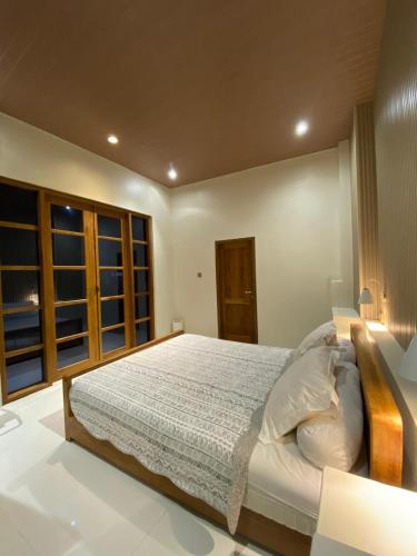 a bedroom with a large bed in a room at NOBE Villas in Salakan