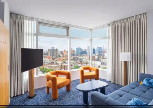 a living room with a couch and a large window at The Standard - East Village in New York