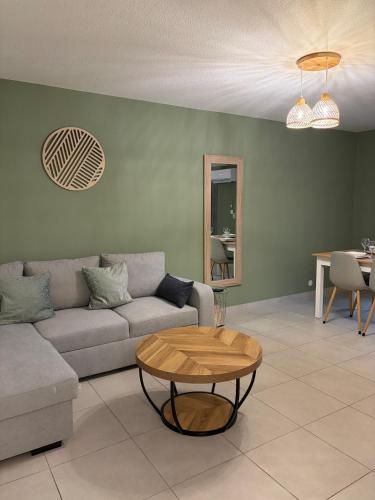 ein Wohnzimmer mit Sofa und Tisch in der Unterkunft Le cocon in Hambach