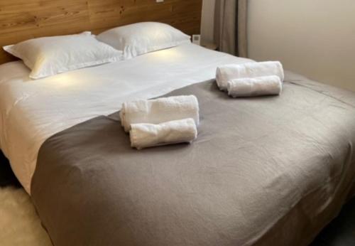 two towels are sitting on top of a bed at Chalet Cosy in Pugny-Chatenod