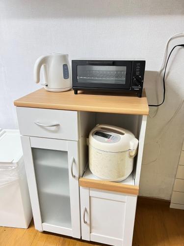 a microwave sitting on top of a small table at Family Home Osaka Awaji Guest House in Osaka