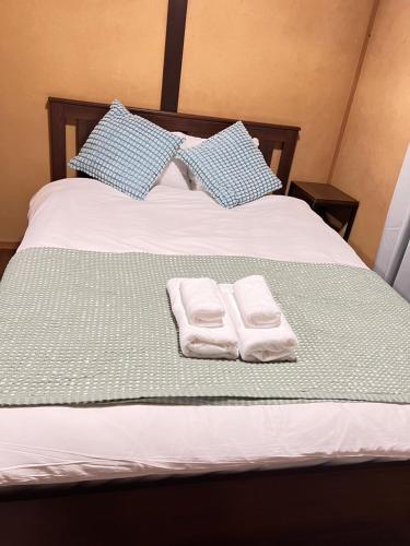 a bed with two towels and two pillows on it at Family Home Osaka Awaji Guest House in Osaka