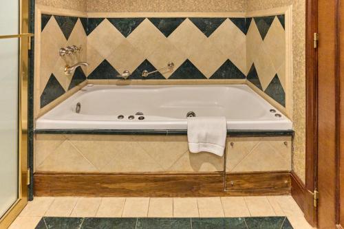 a bath tub in a bathroom with a tile wall at Sheraton Pilar Hotel & Convention Center in Pilar