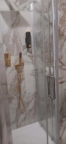 um chuveiro na casa de banho com uma parede em mármore em PRINCIPE ROOMS em Rodigo