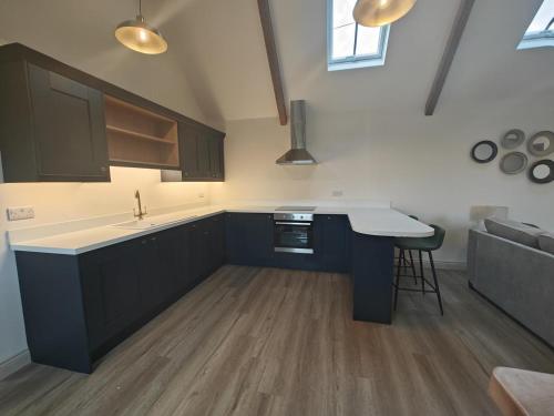 a kitchen with blue cabinets and a sink and a table at 1 Bed in Castleton oc-t34011 in Castleton