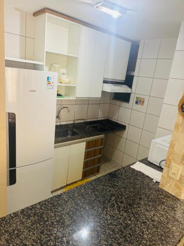 uma cozinha com armários brancos e uma geladeira em Thermas Paradise resorts em Rio Quente