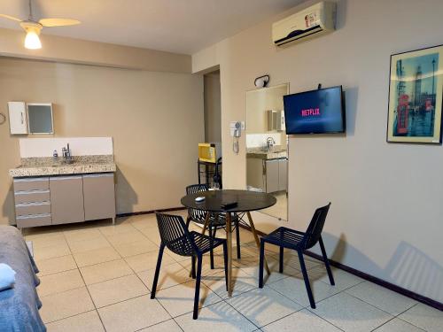 uma sala de estar com mesa e cadeiras e uma cozinha em VA Apart Hotel Savassi em Divinópolis