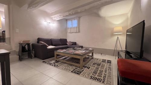 Casa Del Saint Paul في سان بول دي فينس: غرفة معيشة بها أريكة وطاولة