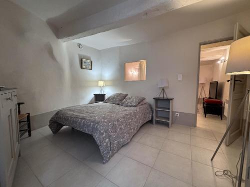 Casa Del Saint Paul في سان بول دي فينس: غرفة نوم بسرير وطاولتين ومرآة