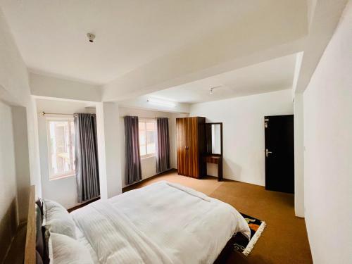 加德满都Himalayan Laligurans Apartments的带窗户的房间里有一张床的卧室