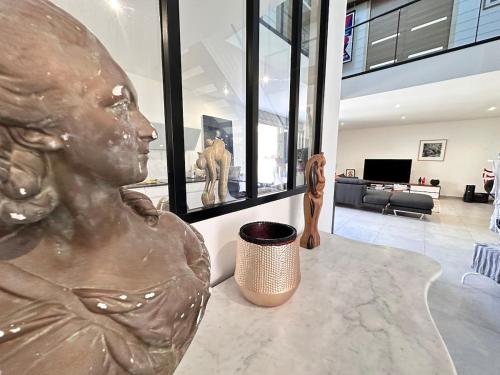 eine Statue einer Frau, die auf einem Tisch in einem Wohnzimmer sitzt in der Unterkunft Calme et détente avec jacuzzi, jardin et terrasse in Trigny