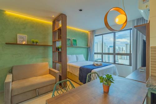 um quarto com uma cama, uma mesa e uma cadeira em Allure Residence by Carpediem em Recife